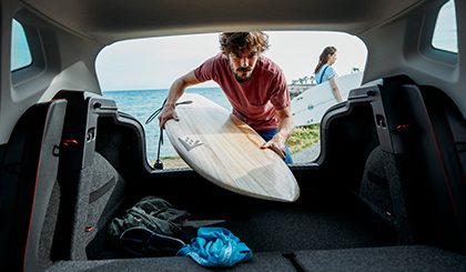 Hombre sacando tabla de surf de la cajuela del nuevo SEAT Ibiza 