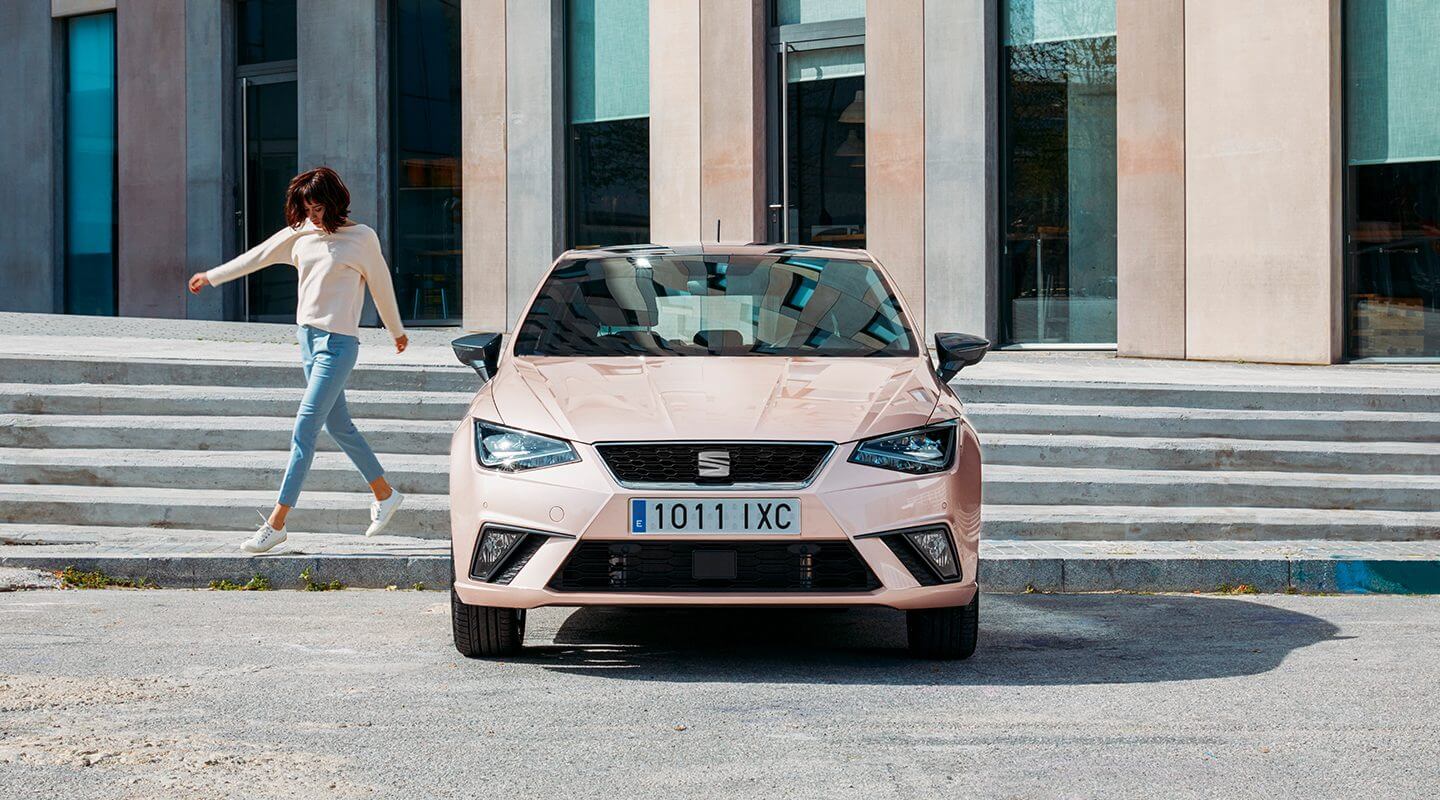 Chica bajando escalinatas para llegar a su nuevo SEAT Ibiza color magenta místico 